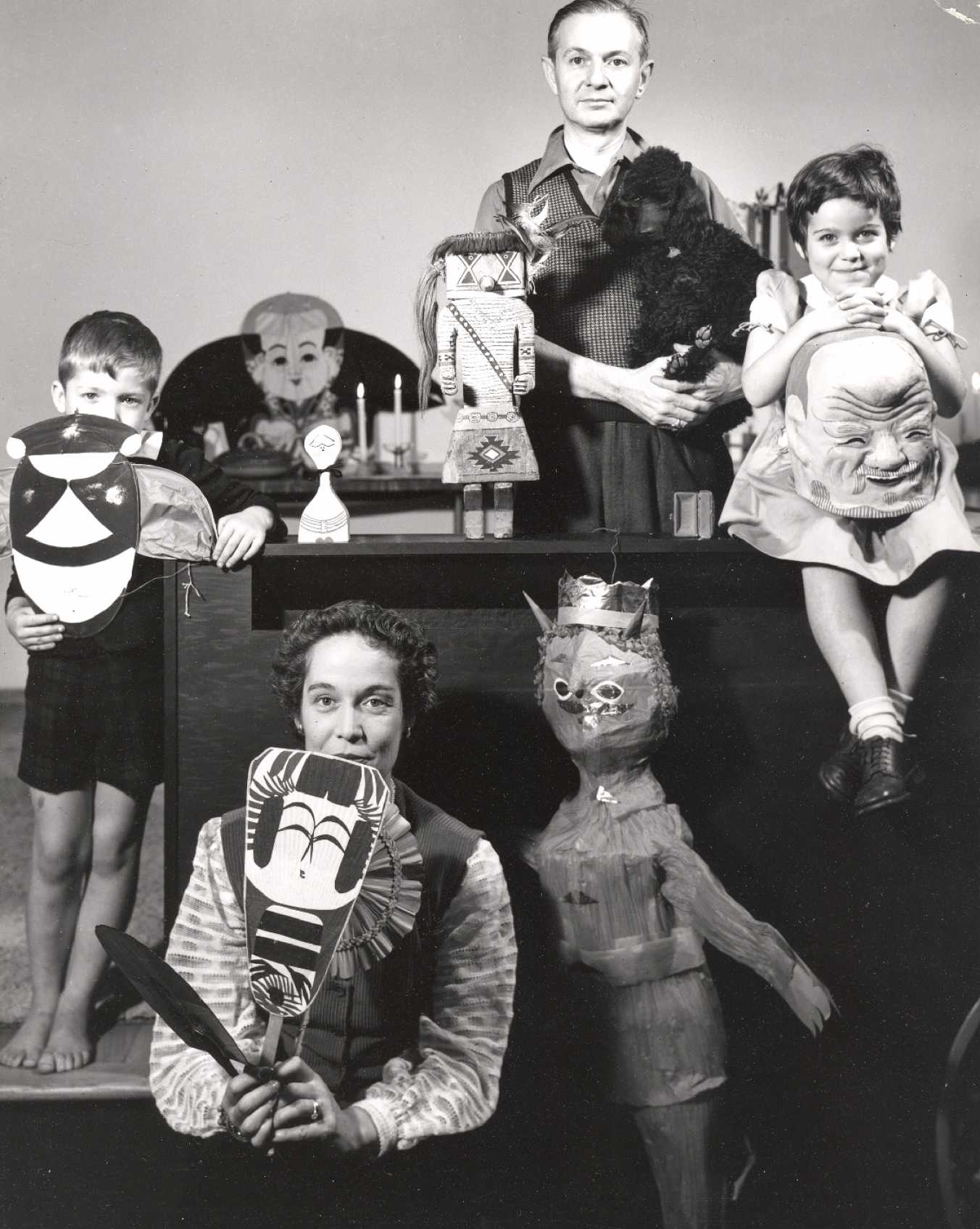 Alexander Girard and his family posing with items from his folk art collection