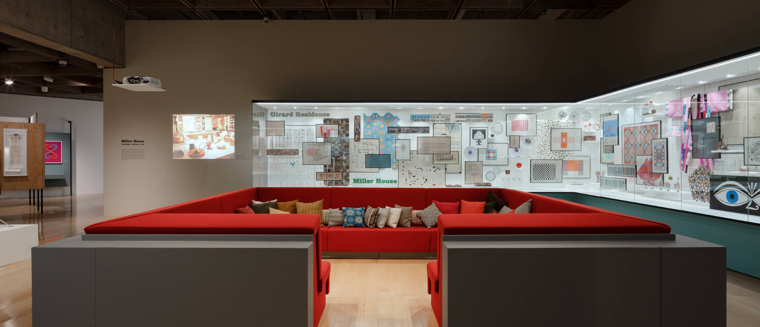 Alexander Girard exhibition, Conversation pit made of red pillows with glass gallery in the back